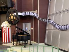 a black piano sitting in front of a movie projector