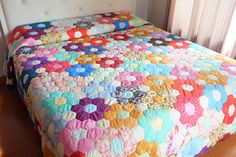 a bed with a colorful quilt on top of it