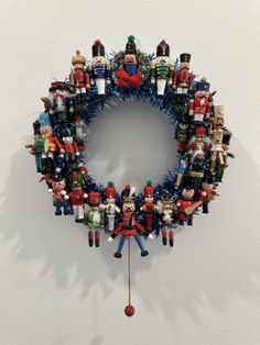 a wreath made out of toy soldiers on a white wall with red and blue tinsel