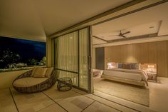 a bedroom with a large bed sitting on top of a wooden floor next to a balcony