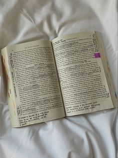 an open book sitting on top of a bed