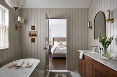 a bath room with a tub a sink and a mirror on the wall next to a window