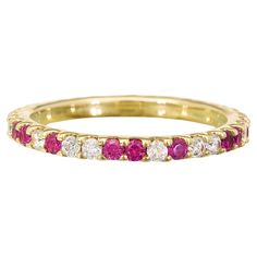 a yellow gold band with pink and white diamonds on it, set in 18k yellow gold