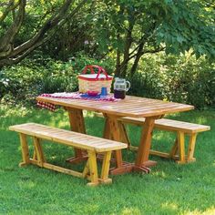 a picnic table with two benches in the grass