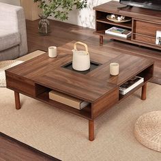 a living room with a couch, coffee table and television on top of the tv stand