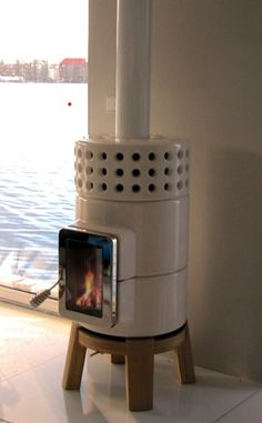 a white stove sitting on top of a wooden stand next to a body of water