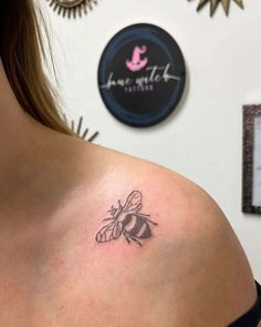 a woman with a bee tattoo on her shoulder