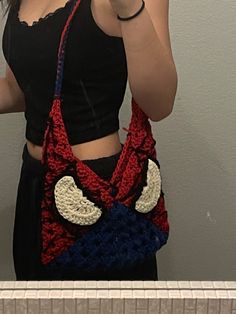 a woman is taking a selfie with her cell phone while wearing a crocheted bag