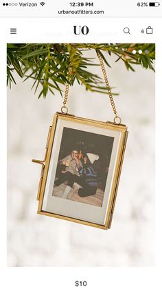 an ornament hanging from a christmas tree with a photo on it's side