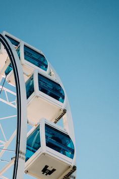 a ferris wheel with multiple windows on it's side and blue sky in the background