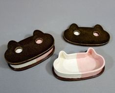 three little cat shaped dishes sitting on top of a table