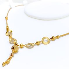 This 22k gold necklace, weighing 9.1 grams, features a trendy design with a dangling orb, polished in a radiant yellow gold finish. The necklace is 17 inches long, with a drop length of 1.25 inches, and includes 1 inch of adjustable links for a perfect fit, secured by an S lock. The singular orb adds a modern touch, making this piece a standout accessory. Ideal for those seeking a blend of contemporary style with the timeless elegance of gold, this necklace is perfect for adding a touch of sophistication to any look, whether for daily wear or special occasions. PRODUCT DETAILS Gold Purity(karat): 22k Gold Weight(grams): 9.1 Item Finish: Yellow Gold Necklace Length: 17" Drop Length: 1.25" Adjustable Links: 1" Links Lock Style: S Lock 22k Gold Necklace, Lock Style, Yellow Gold Necklace, 22k Gold, Necklace Length, Gold Finish, Contemporary Style, Timeless Elegance, Daily Wear