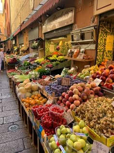 an outdoor market with lots of fruits and vegetables