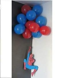 a spiderman balloon hanging from the side of a wall