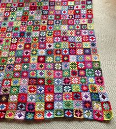 a crocheted blanket is laying on the floor