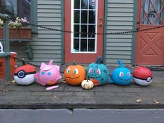 several pumpkins with faces painted on them are lined up in front of a house