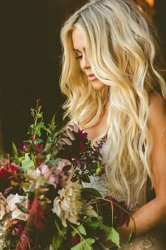 a beautiful blonde woman holding a bouquet of flowers