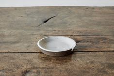 a white bowl sitting on top of a wooden table