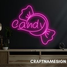 a neon sign that says candy on it in front of a black wall with the word candy