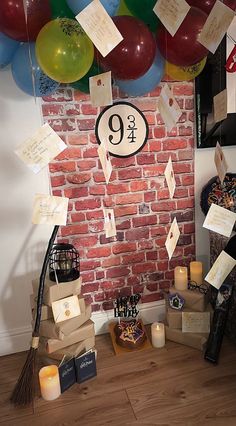 a room with balloons, candles and other items on the floor in front of a brick wall