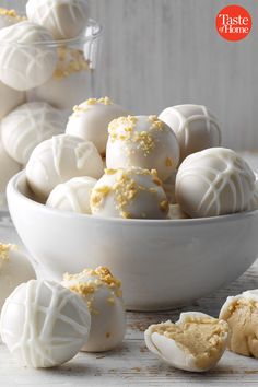 some white chocolates are in a bowl and on the table next to other pieces