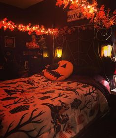 a bedroom decorated for halloween with pumpkins and decorations on the headboard, lights strung from above