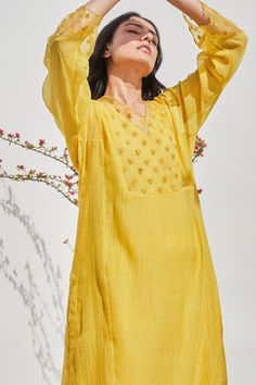 Daisy yellow chanderi kurta with V neck, all over polka dot pattern, tonal floral dori, sequin, dabka embroidered yoke and sleeve border sheer panels. Paired with palazzo, silk organza embroidered dupatta and inner slip.
Components: 4
Pattern: Embroidered
Type Of Work: Dori, Sequin Work, Polka Dot Pattern
Neckline: V Neck
Sleeve Type: Kurta: Full Sleeves, Inner Slip: Sleeveless
Fabric: Chanderi, Dupatta: Silk Organza
Color: Yellow
Other Details: 
Embroidered border on palazzo
Scalloped cut work Bohemian Long Sleeve Blouse For Puja, Summer Chanderi Kurta With Resham Embroidery, Summer Chanderi Dress With Cutdana Detail, Bohemian Kurta With Cutdana For Puja, Bohemian Handloom Blouse For Festive Occasions, Designer Tunic Kurta For Summer, Bohemian Blouse With Self Design For Eid, Summer Cutdana Chanderi Dress, Summer Bohemian Kurta With Self Design