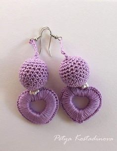 the earrings are knitted in purple and have heart shaped bead details on them