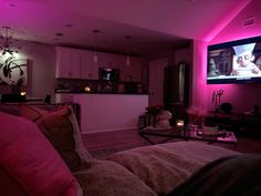 a living room filled with furniture and a flat screen tv mounted to the side of a wall