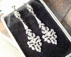 "Offering a beyond exquisite pair of vintage Art Deco pave rhinestone flapper long pendant dangle earrings. These look like they are right off the set of \"Downton Abbey\" and will be the perfect \"Something Old\" for the Bride and with a pair of jeans and a tee afterwards. Photos do not capture the sparkle adequately! The circa 1930 - 1940 ornate silver rhodium plated earrings are pave set with baguette cut as well as tiny round cut brilliantly clear sparkly crystal rhinestones. Earrings are de Victorian Earrings With Diamond Accents For Wedding, Victorian Wedding Earrings With Diamond Accents, Vintage Silver Bridal Earrings For Evening, Vintage Bridal Earrings With Intricate Design, Vintage Bridal Earrings With Intricate Design For Formal Occasions, Antique Chandelier Earrings For Wedding, Vintage Bridal Earrings For Wedding, Vintage Silver Chandelier Earrings For Wedding, Silver Vintage Chandelier Earrings For Wedding