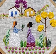 two women are standing in the grass and one is holding a flower with her hand