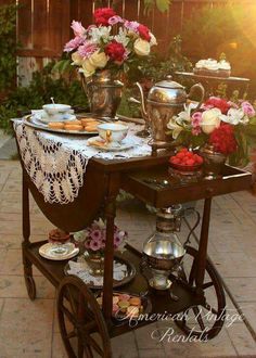 a table that has some plates on it and flowers in vases next to it