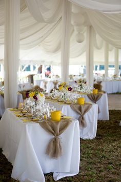 the tables are set up with yellow and white centerpieces, napkins, and cups