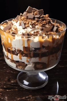 an ice cream sundae with caramel and chocolate toppings on top, in a glass trifle dish