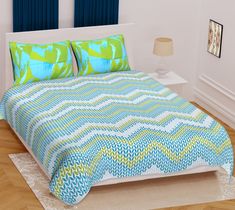 a bed with blue and green bedspread on top of it