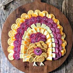 a wooden platter with crackers and cheeses on it, including beets