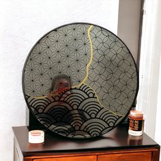 a round mirror sitting on top of a wooden dresser