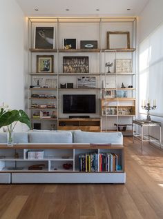 a living room filled with furniture and a flat screen tv on top of a wooden shelf