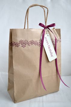 a brown paper bag with a purple ribbon