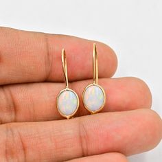 Natural Australian Opal Earrings (Pair) ✪Gemstone: Natural Australian Opal  ✪Metal: 18k solid Yellow gold. ✪Stone size: 6x8 mm. ✪Stone Shape :Oval  ✪Stone Weight : 2 Ct. ✪ Earring Weight : 1.25 Gram ✪Earring Length : 25 mm. ✪Earring width : 7 mm. ✪Setting type: Bezel wire setting. If you need any other preferred stone please contact us. Opal benefits - *The stone is believed to counteract bad effects and bring prosperity, beauty, love, and romance in like.  *It brings success in dating and benefits those who are in dairy and hospitality industry. *Opal gemstone benefits include enhancing joy in marital life.   QUALITY OF MATERIALS: Metal: Most of our jewelry at JewelryMansion is made with precious metals like gold and silver. These metals are 100% non-allergic to our skin. Gemstone: All of Opal Benefits, Bezel Wire, Opal Earring, Bezel Earrings, Life Quality, Solid Gold Earrings, Birthstone Gifts, Hospitality Industry, Gold Stone