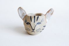 a small ceramic cat head on a white background