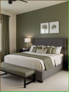 a bedroom with green walls and white bedding in the center, two framed pictures on the wall