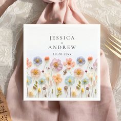 an image of a wedding card with flowers on it and gold cutlery next to it