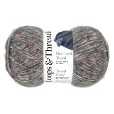 yarn ball in grey with red and white stripes on the end, next to an advert