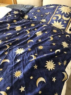 a bed with blue sheets and gold stars on it