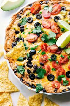 a tortilla topped with black olives, tomatoes and avocado