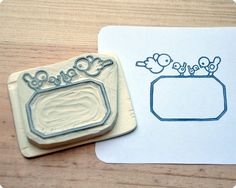 two rubber stamps sitting next to each other on top of a wooden table with paper