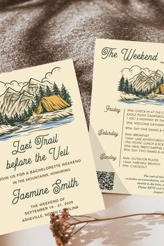 two wedding cards sitting on top of a bed next to each other with mountains in the background