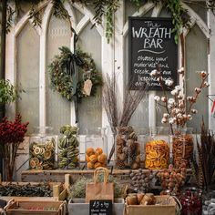 an assortment of dried fruits and vegetables on display in front of a building with wreaths