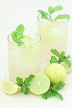 two glasses filled with lemonade, lime and mint